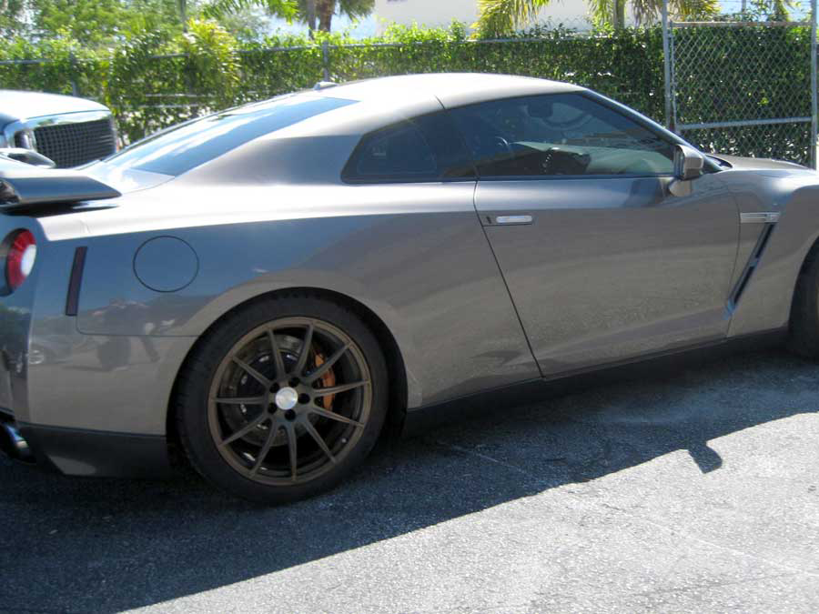 A gray sports car is parked in a parking lot | B & R Auto Body Works