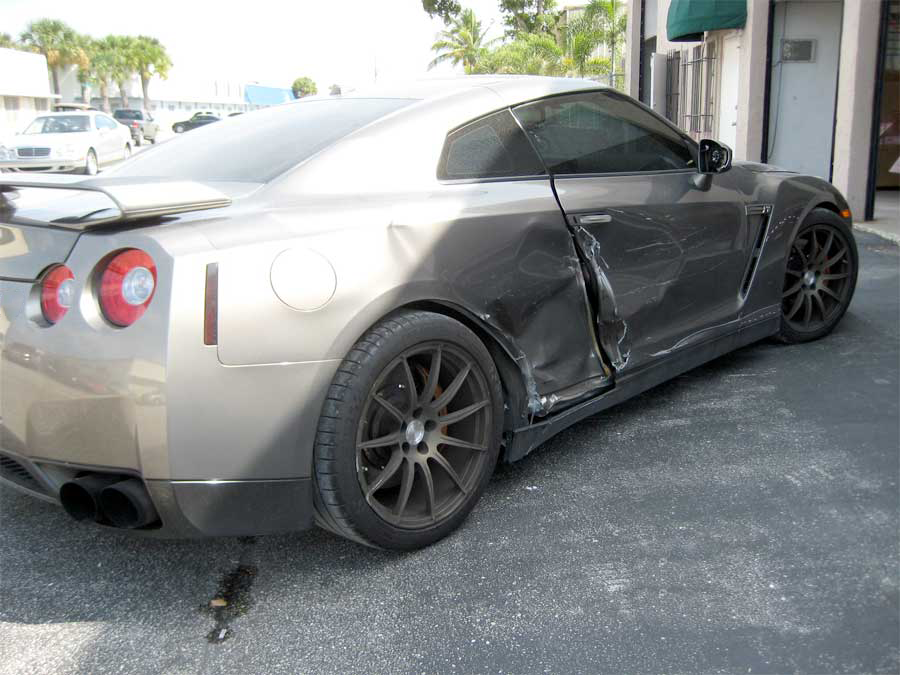 A damaged sports car is parked in a parking lot | B & R Auto Body Works