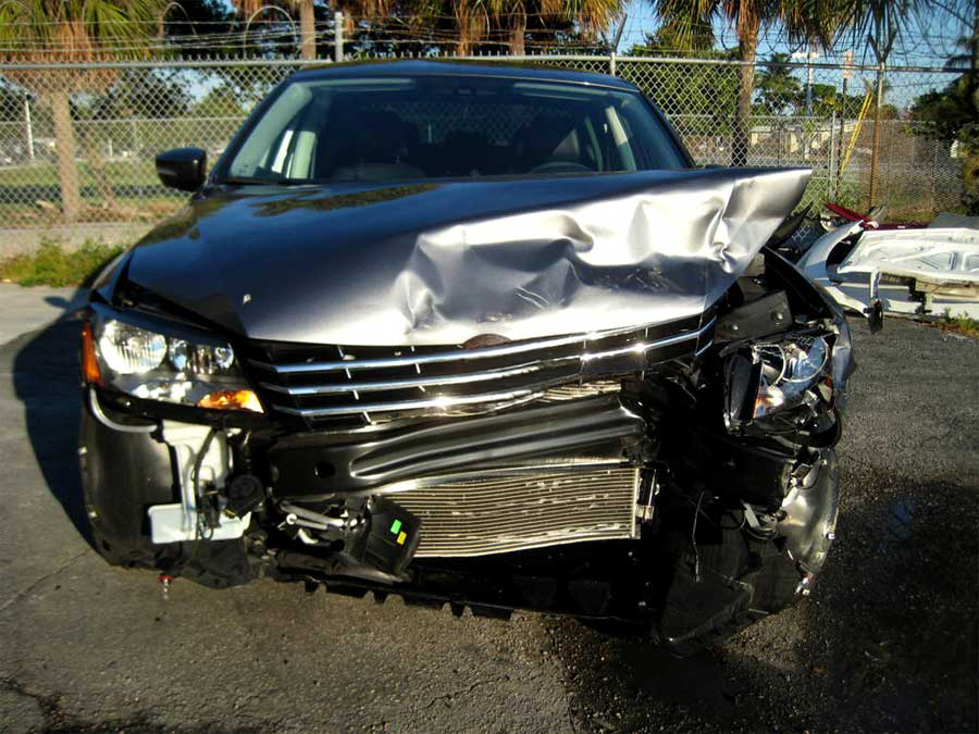 A damaged car is parked on the side of the road | B & R Auto Body Works