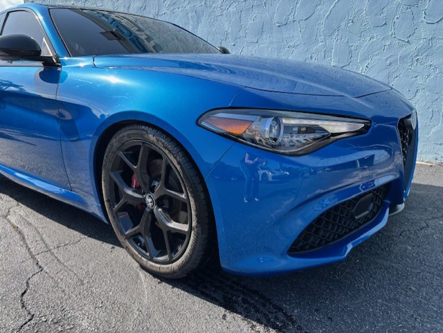 A blue sports car is parked in a parking lot | B & R Auto Body Works