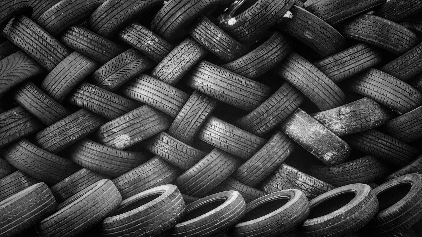 Black-and-white close-up of stacked woven and braided tire-like loops forming a textured pattern