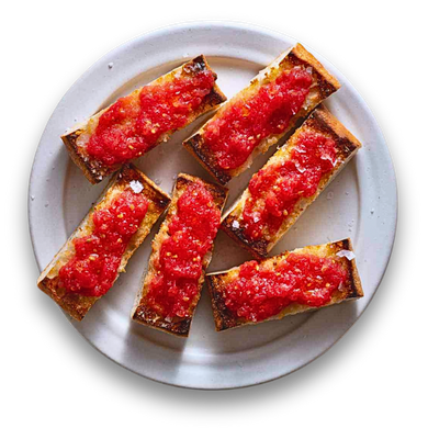 Toasted bread slices topped with bright red tomato, served on a white plate.