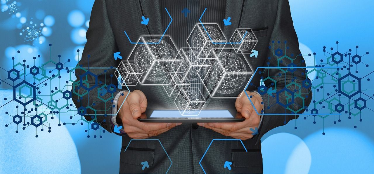 Person in suit holding tablet with glowing cube graphics.