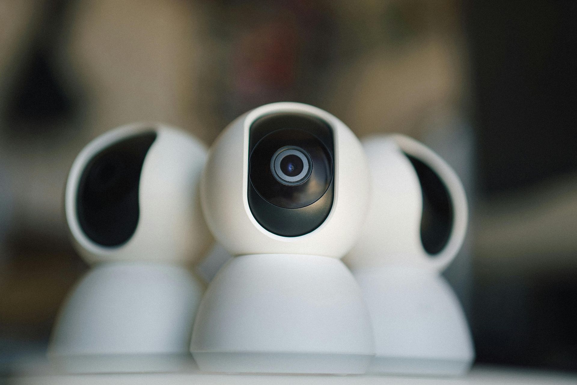 Three white spherical smart security cameras grouped together on a surface.