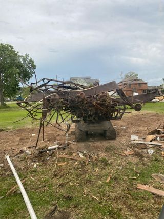 A pile of wood is sitting on top of a tractor in a field.