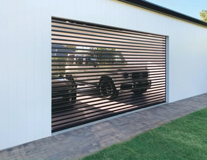 A modern home with a pool, featuring a closed, striped security shutter on the garage and bright blue sky.