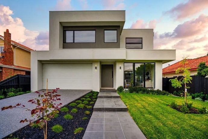 A modern home with a pool, featuring a closed, striped security shutter on the garage and bright blue sky.