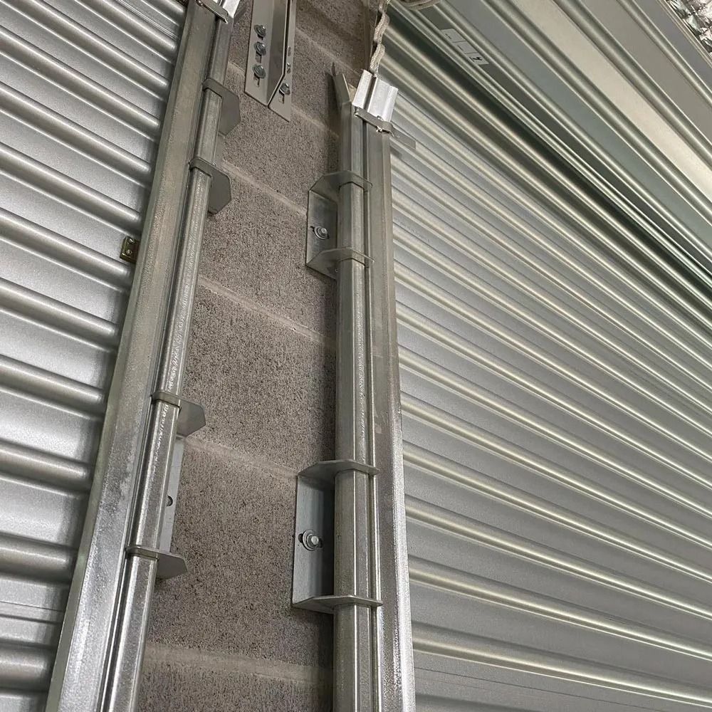 Metal rolling shutter with track and wall brackets, showing installation details.