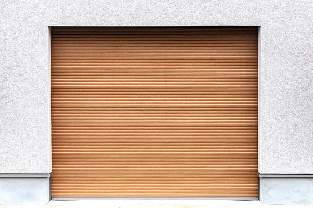 Dark gray roller shutter garage door in a brick building.