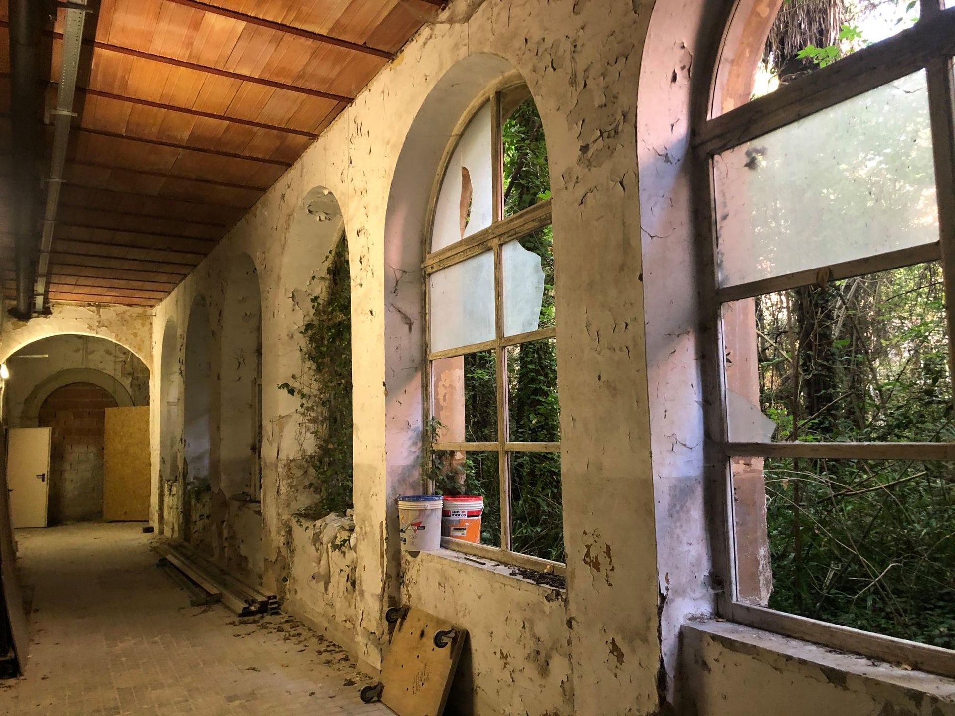 Un corridoio con finestre ad arco e soffitto in mattoni