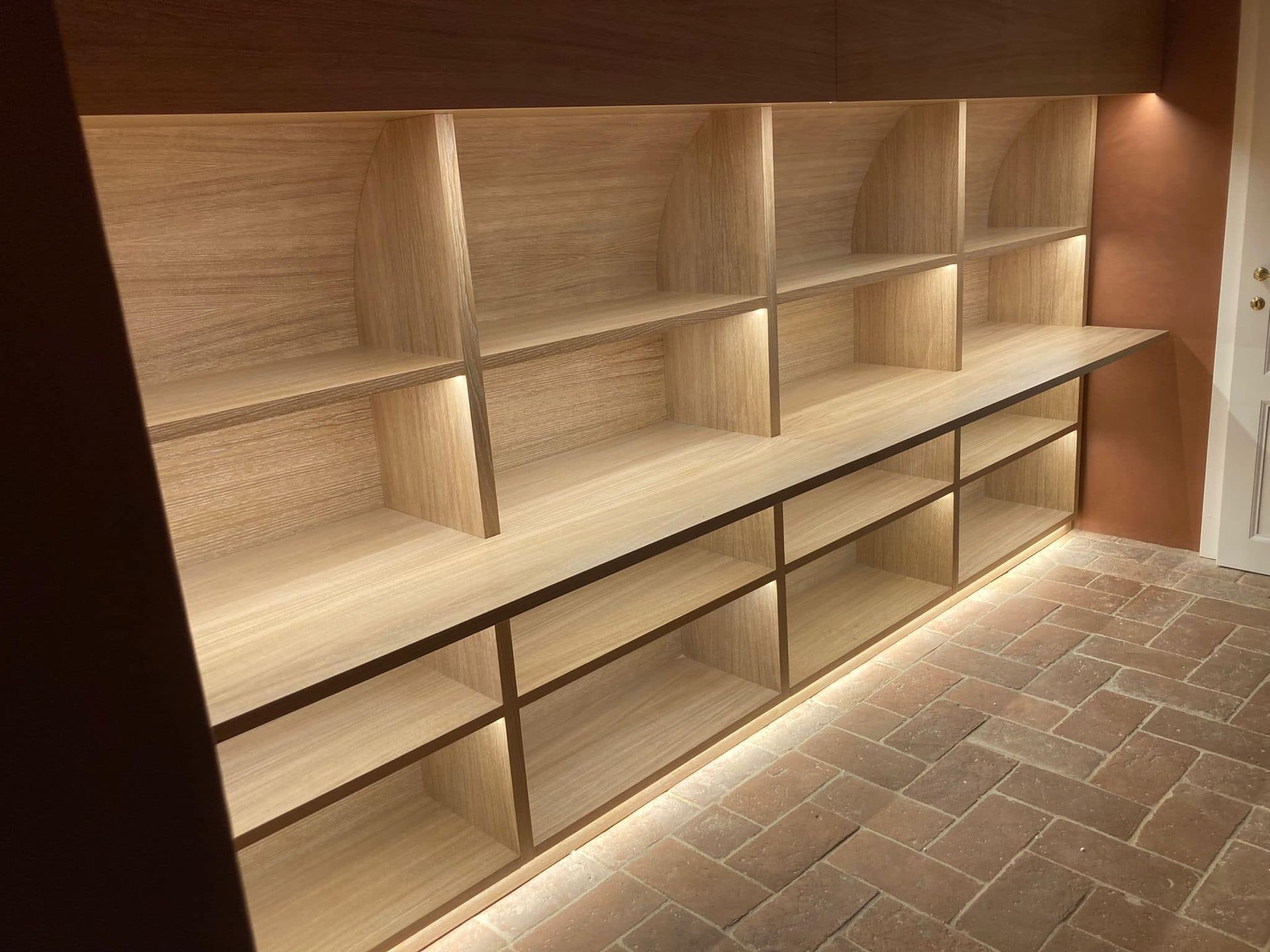 Una stanza con scaffali di legno e pavimento piastrellato.