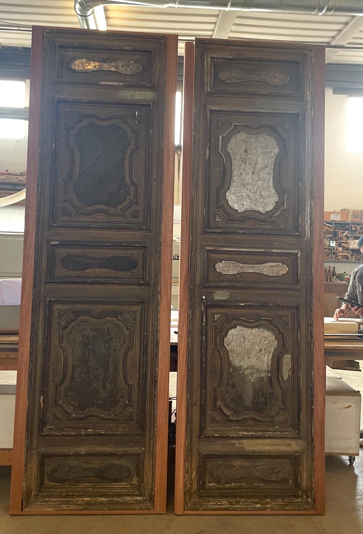 Una coppia di porte di legno sono posizionate una accanto all'altra in una stanza.