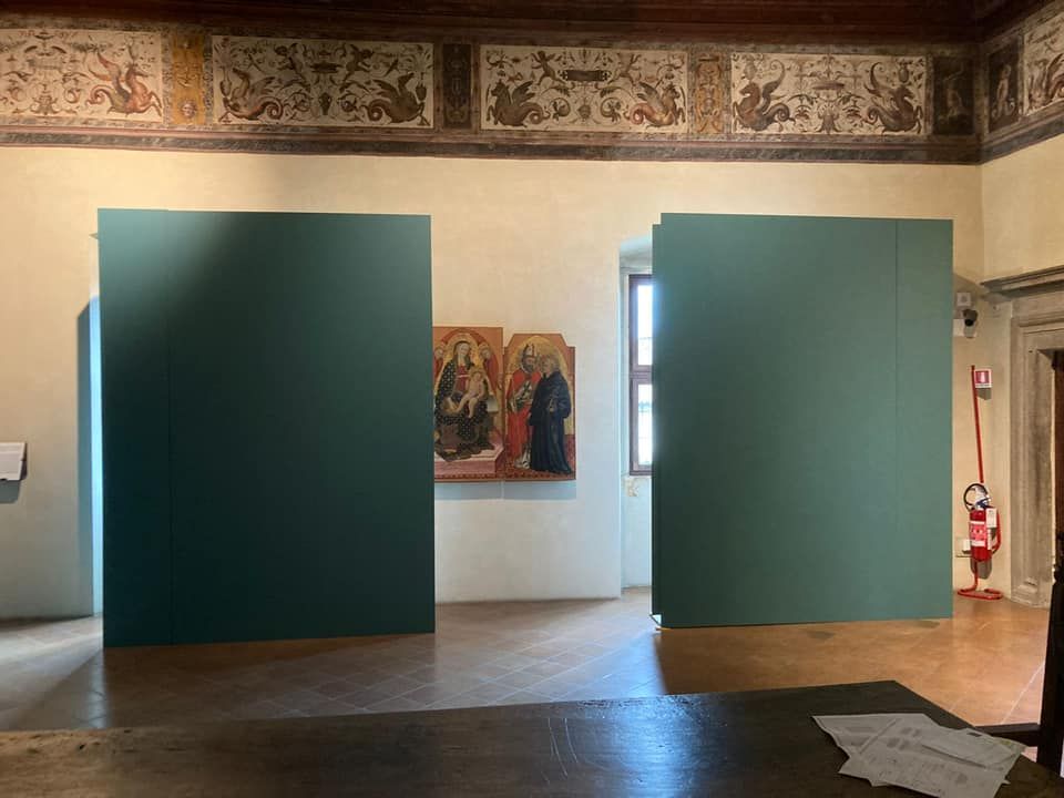 Una stanza con due pareti verdi e un dipinto sul muro.