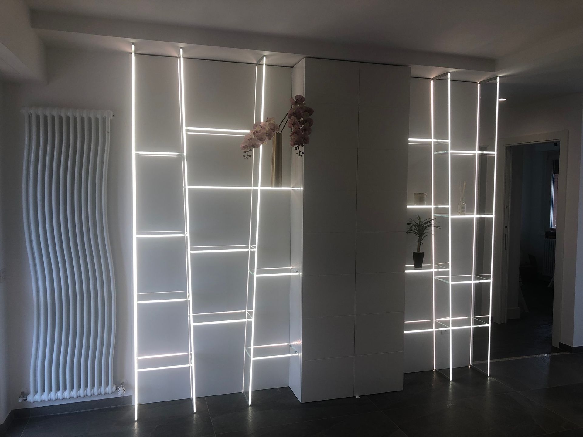 Una stanza con un termosifone bianco e una mensola con luci sopra