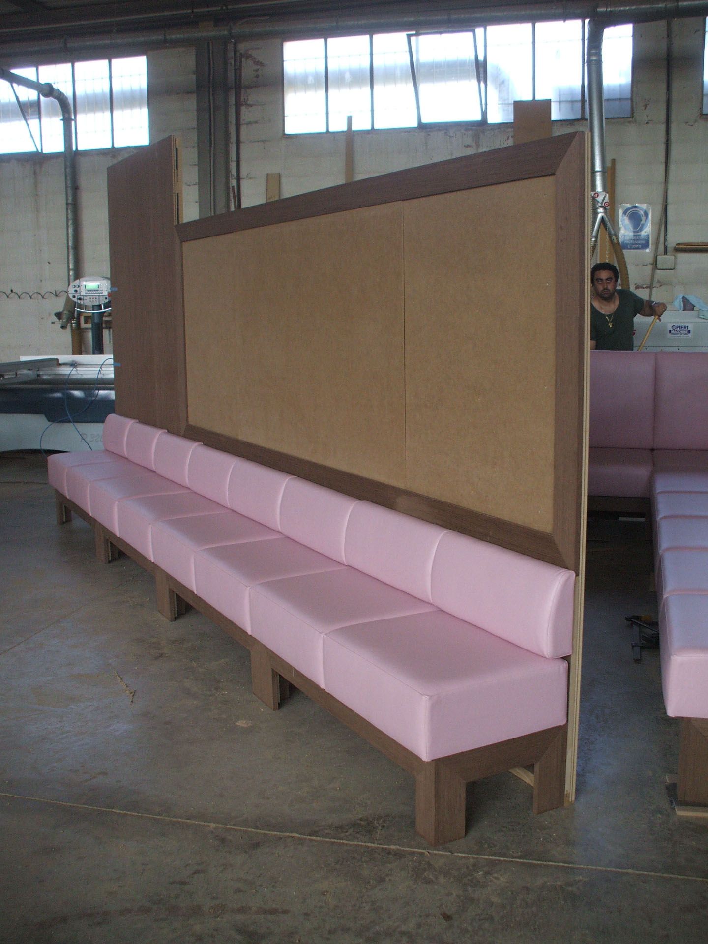 Una fila di panchine rosa davanti a un muro