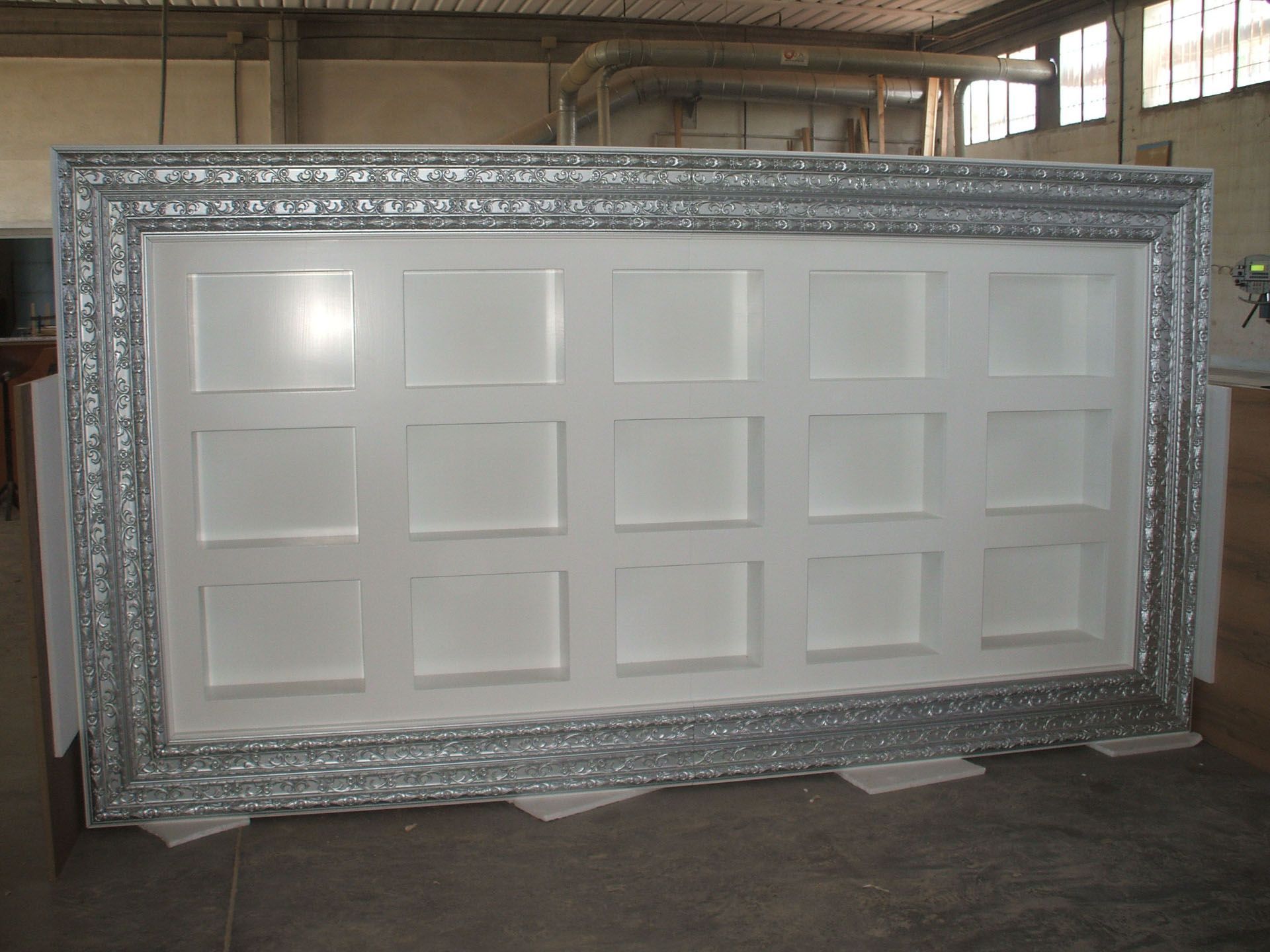 Un muro bianco con una cornice argentata