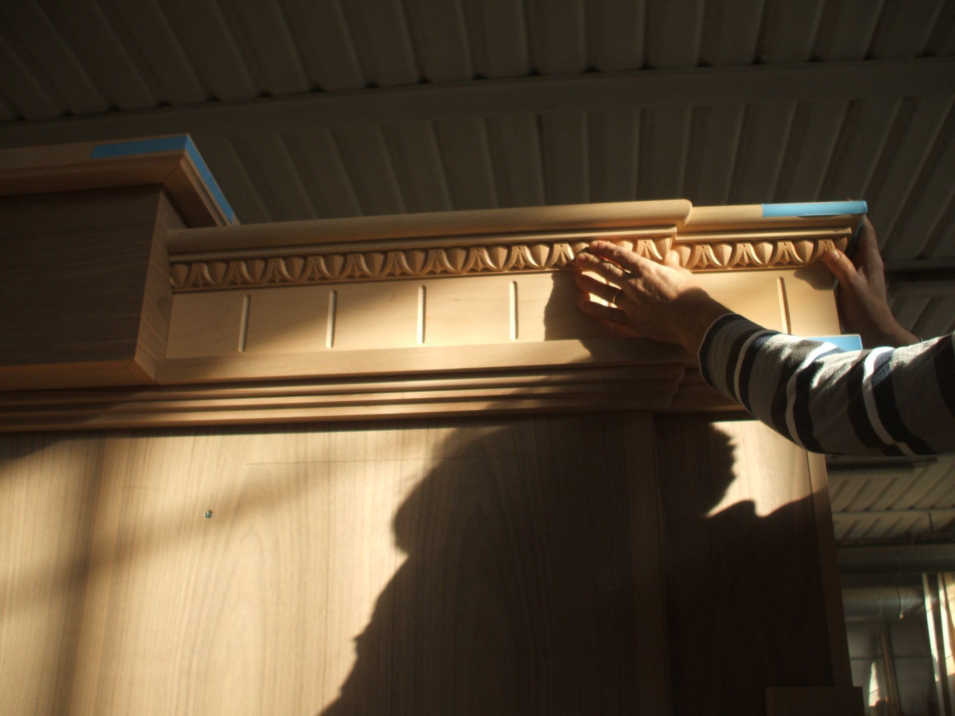 Una persona tiene in mano un pezzo di legno con una modanatura.