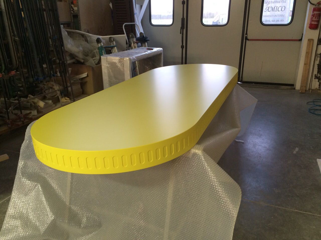 Un tavolo giallo è seduto in una stanza accanto a una porta