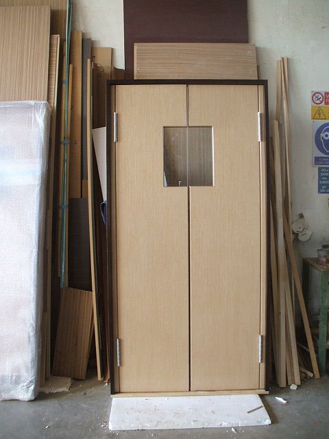 Una porta di legno con una piccola finestra al suo interno
