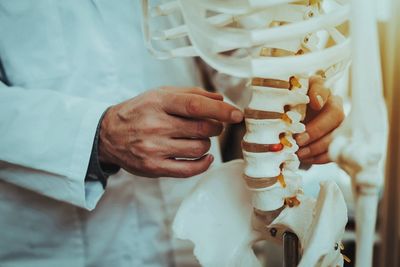 Doctor Holding And Showing Vertebrae On Skeleton — Tyler, TX — Tyler Chiropractic