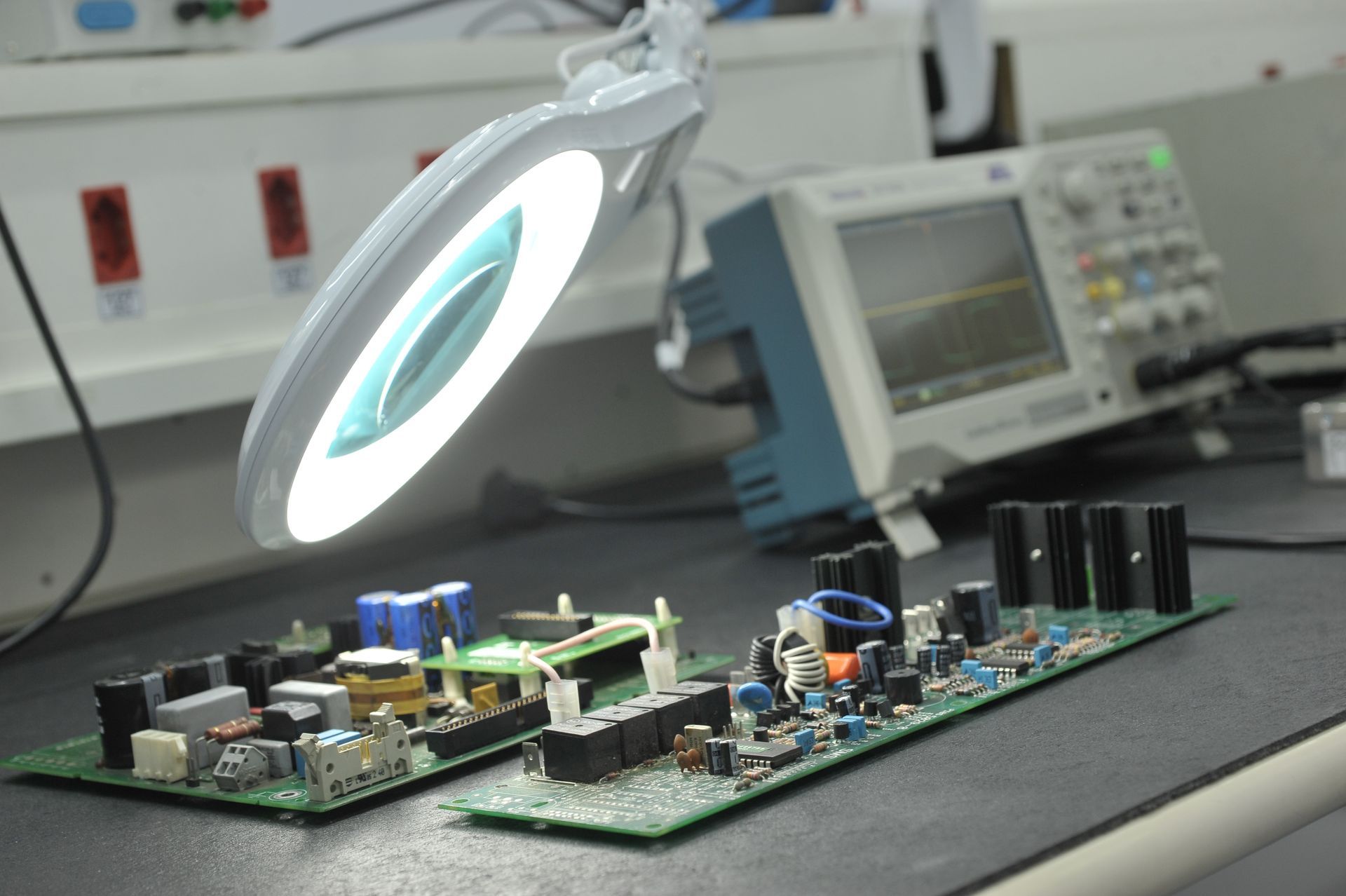 Um homem usando máscara e luvas está trabalhando em uma placa-mãe.