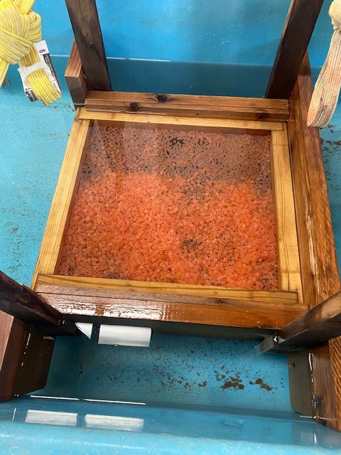 A wooden stool with a glass top is sitting on top of a blue table.