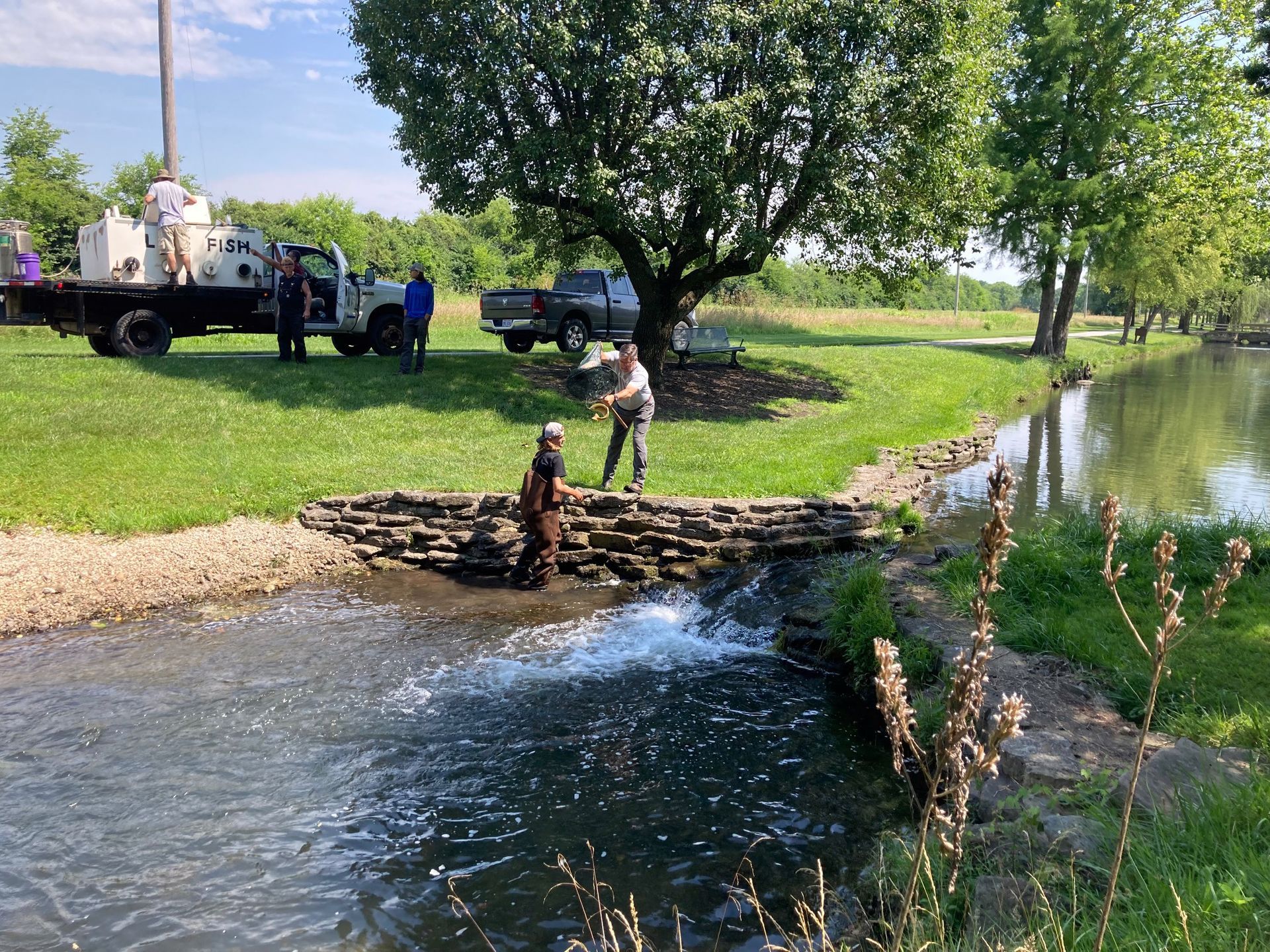 A group of people are working on a bridge over a river.