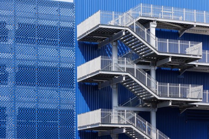 Blue factory with metal fire escape and ladder