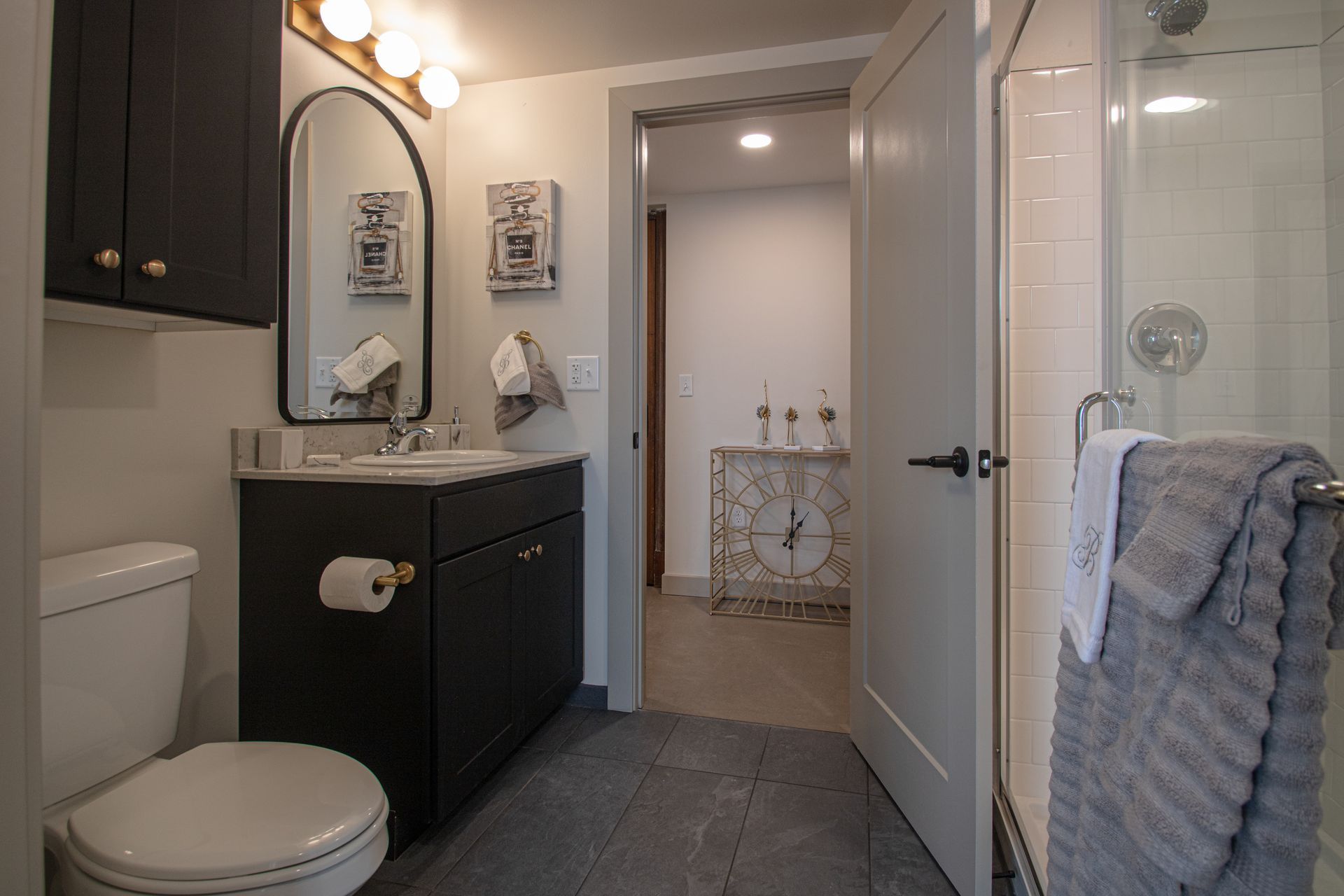 High-End Apartments in Sioux City, IA - Badgerow Flats - Bathroom with Tile Flooring, a Glass Door Shower, and a Modern Sink Vanity