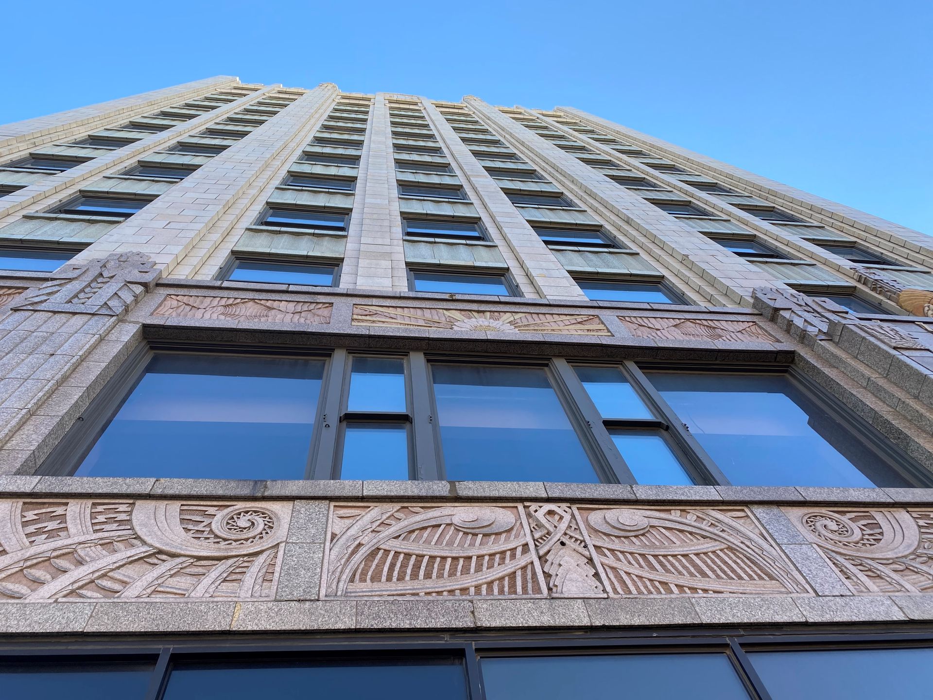 Looking up at a tall building with a blue sky in the background