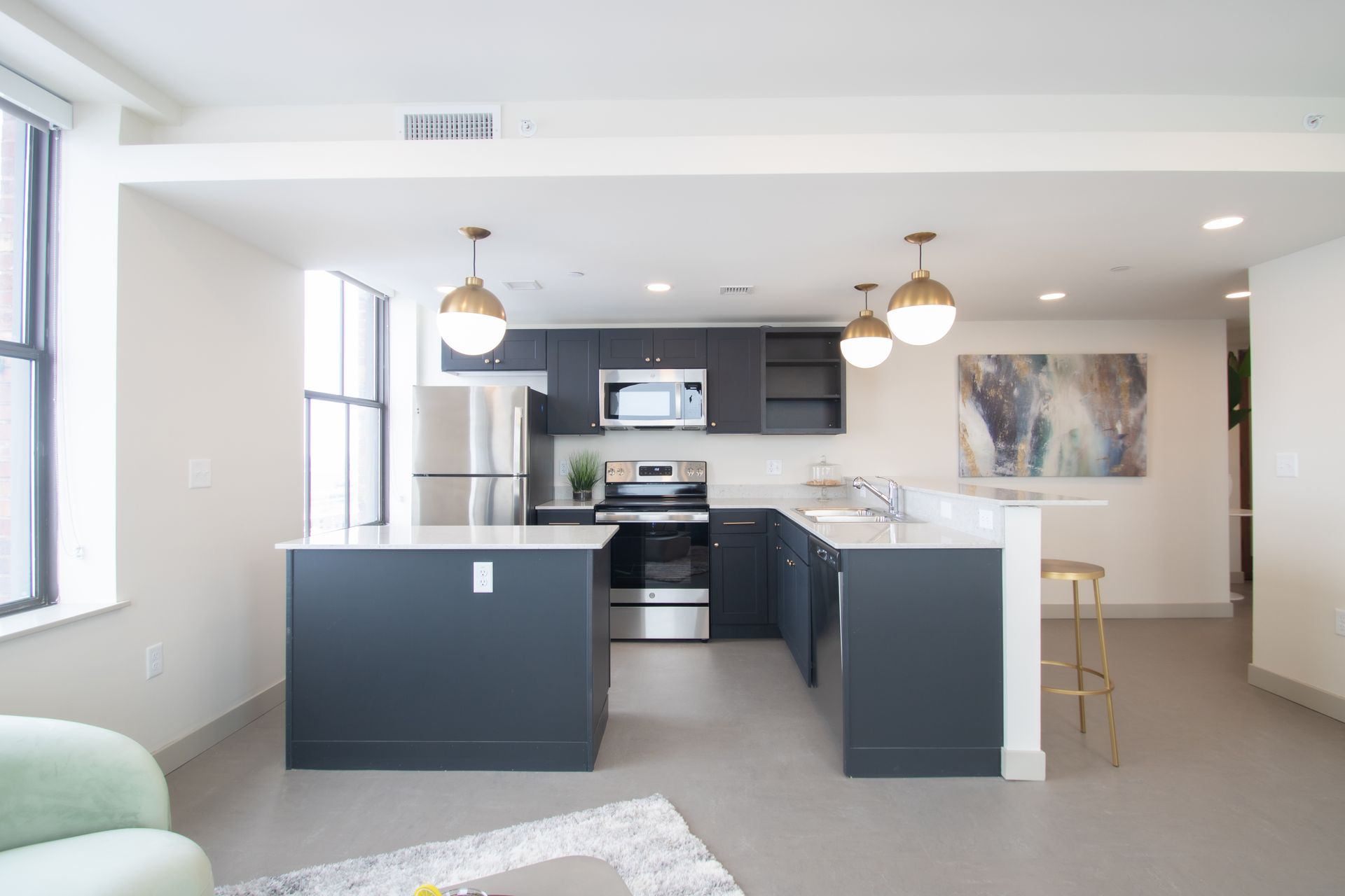 A kitchen with black cabinets and stainless steel appliances