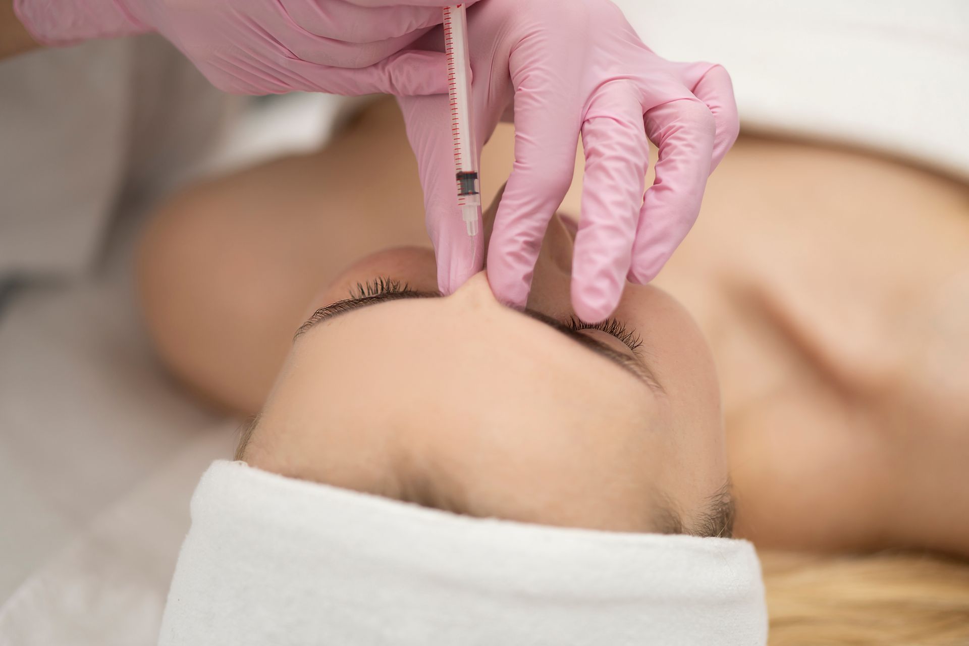 A woman is getting a botox injection in her face.