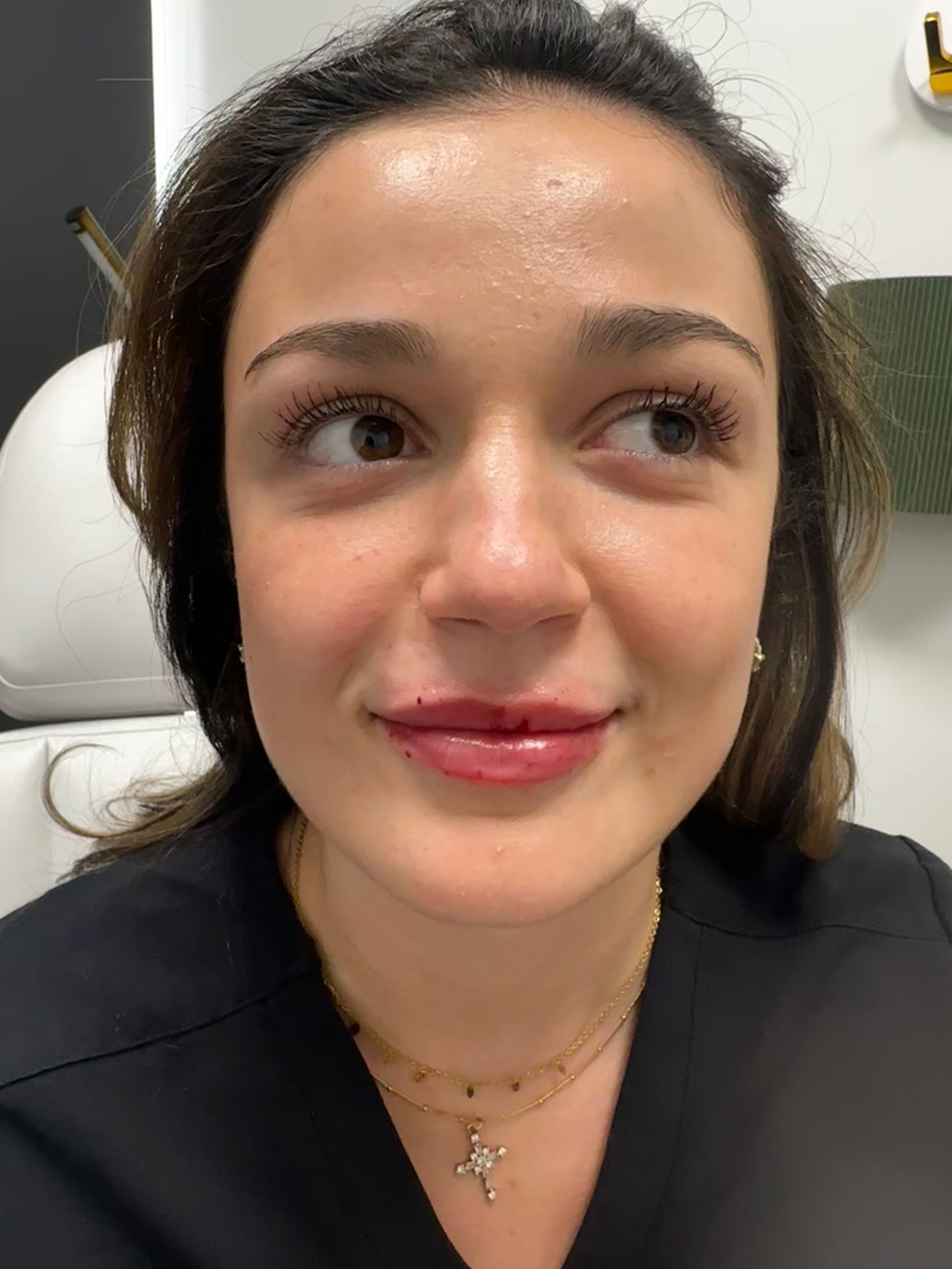 A close up of a woman 's face with a cross necklace.
