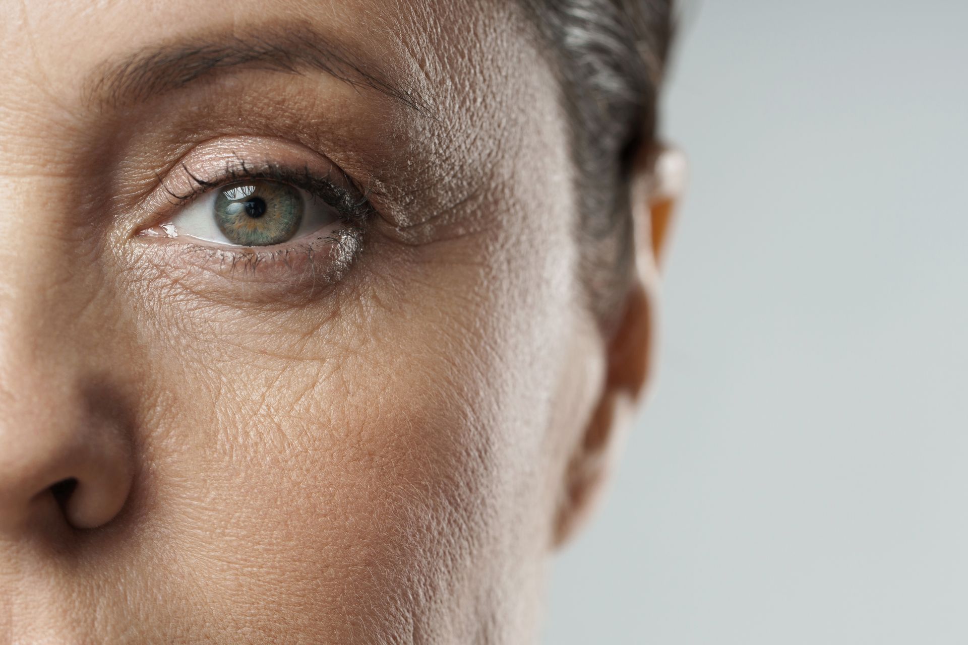 A close up of a woman 's eye with a tear coming out of it.