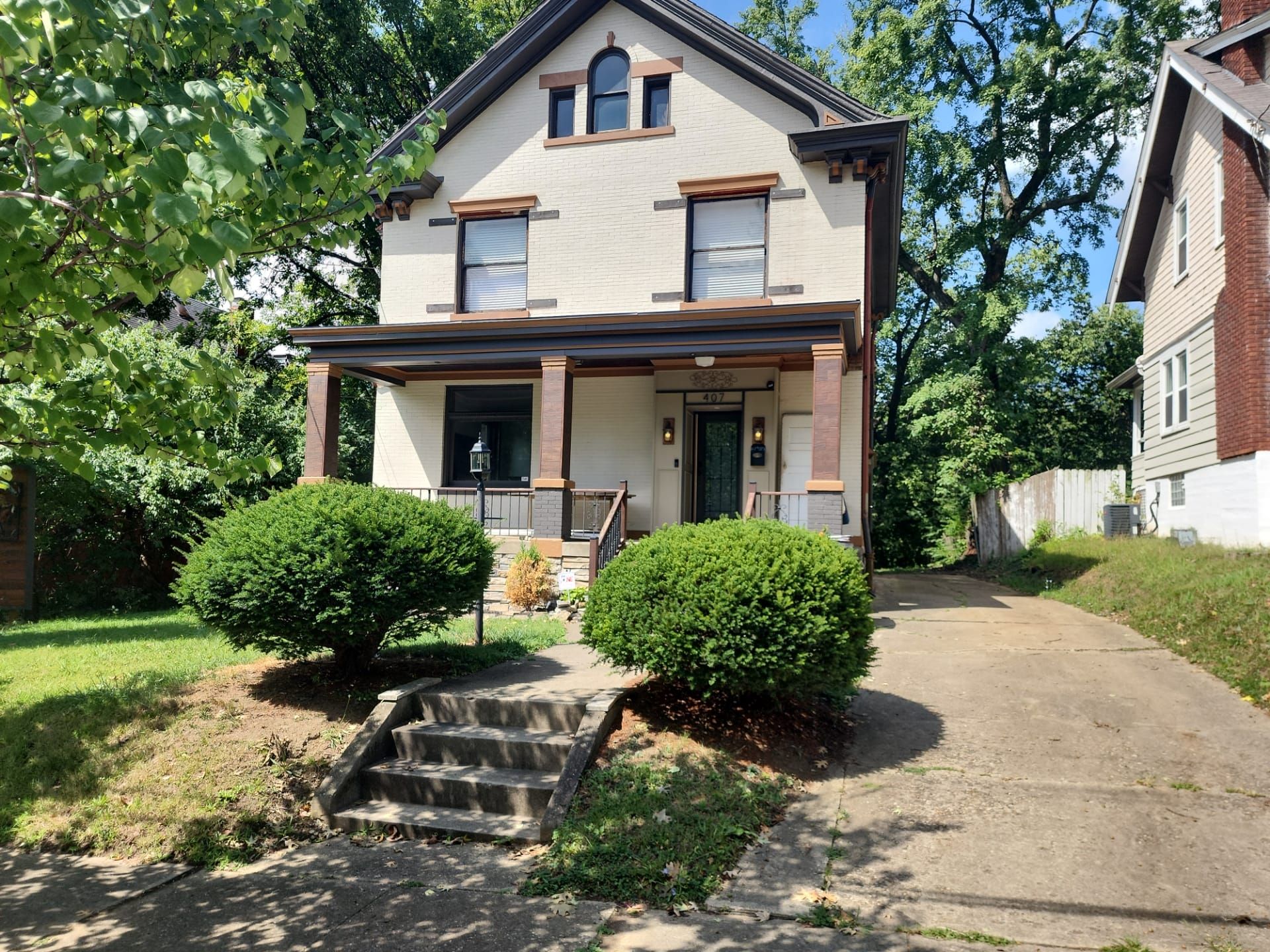 A white house with a porch and stairs in front of it