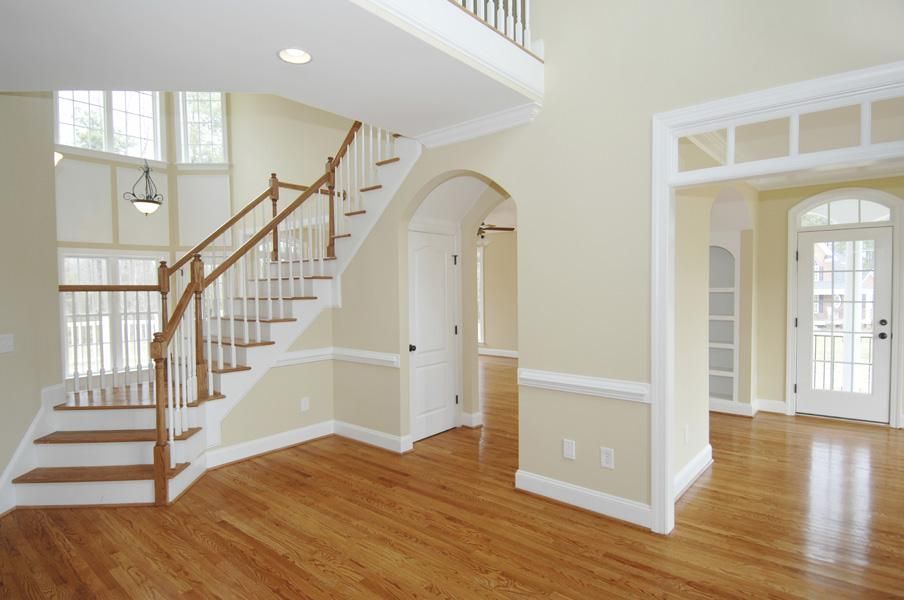 An empty house with a staircase and hardwood floors