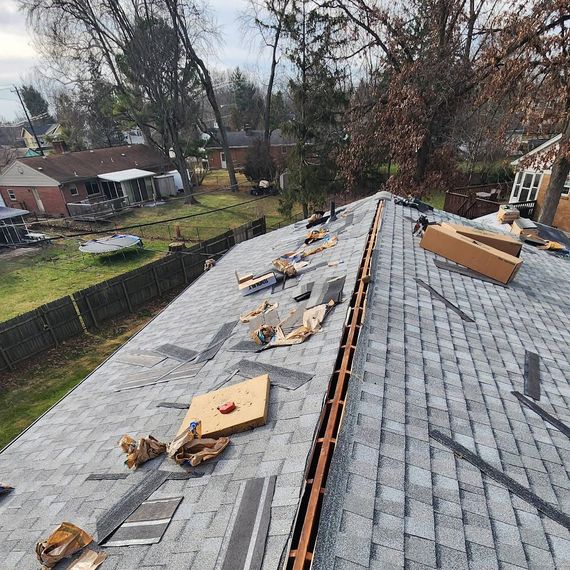 The roof of a house is being repaired with a lot of tools on it.