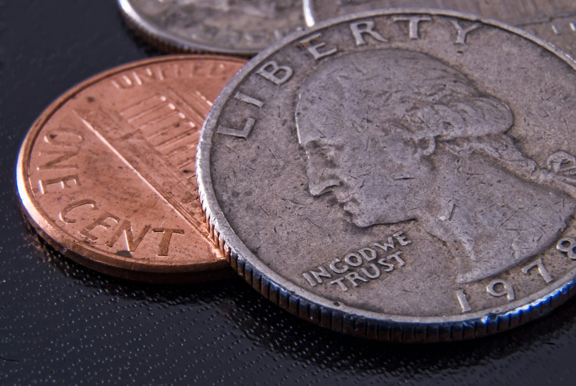 Close-up of US coins: a copper penny and a silver quarter, with 