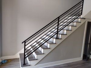 A staircase with a black railing in a living room.