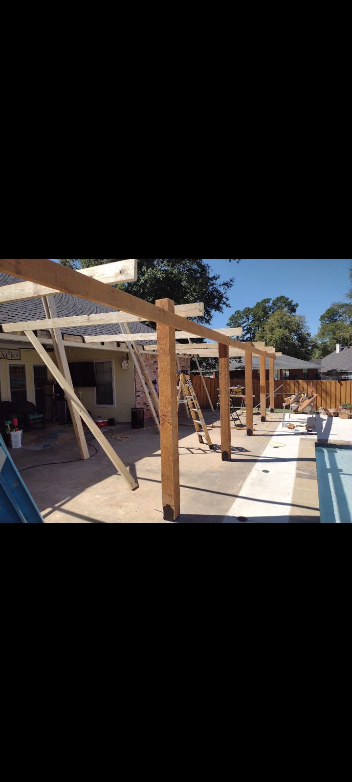 A wooden structure is being built in front of a house.