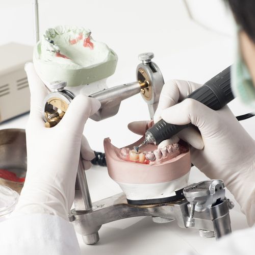Dental Technician Working with Articulator in Dental Laboratory — Dental Clinic in Maroochydore, QLD