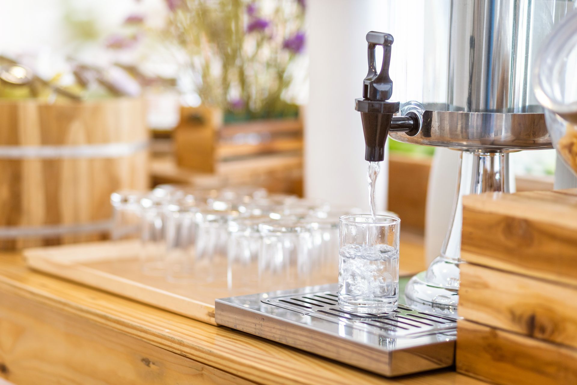 A glass of water is being poured from a dispenser into a glass.