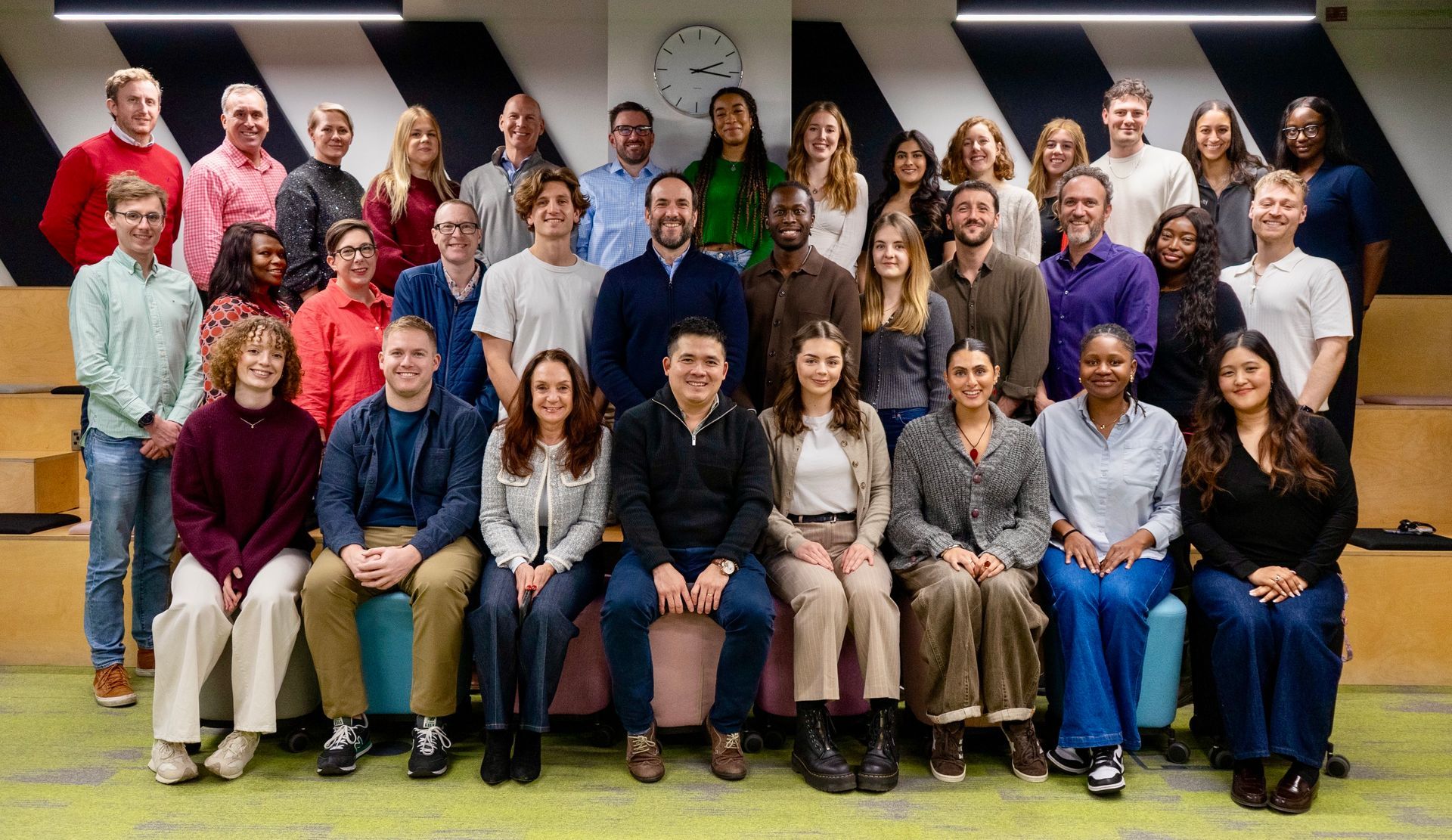 A group of people are posing for a picture in front of a colorful wall.
