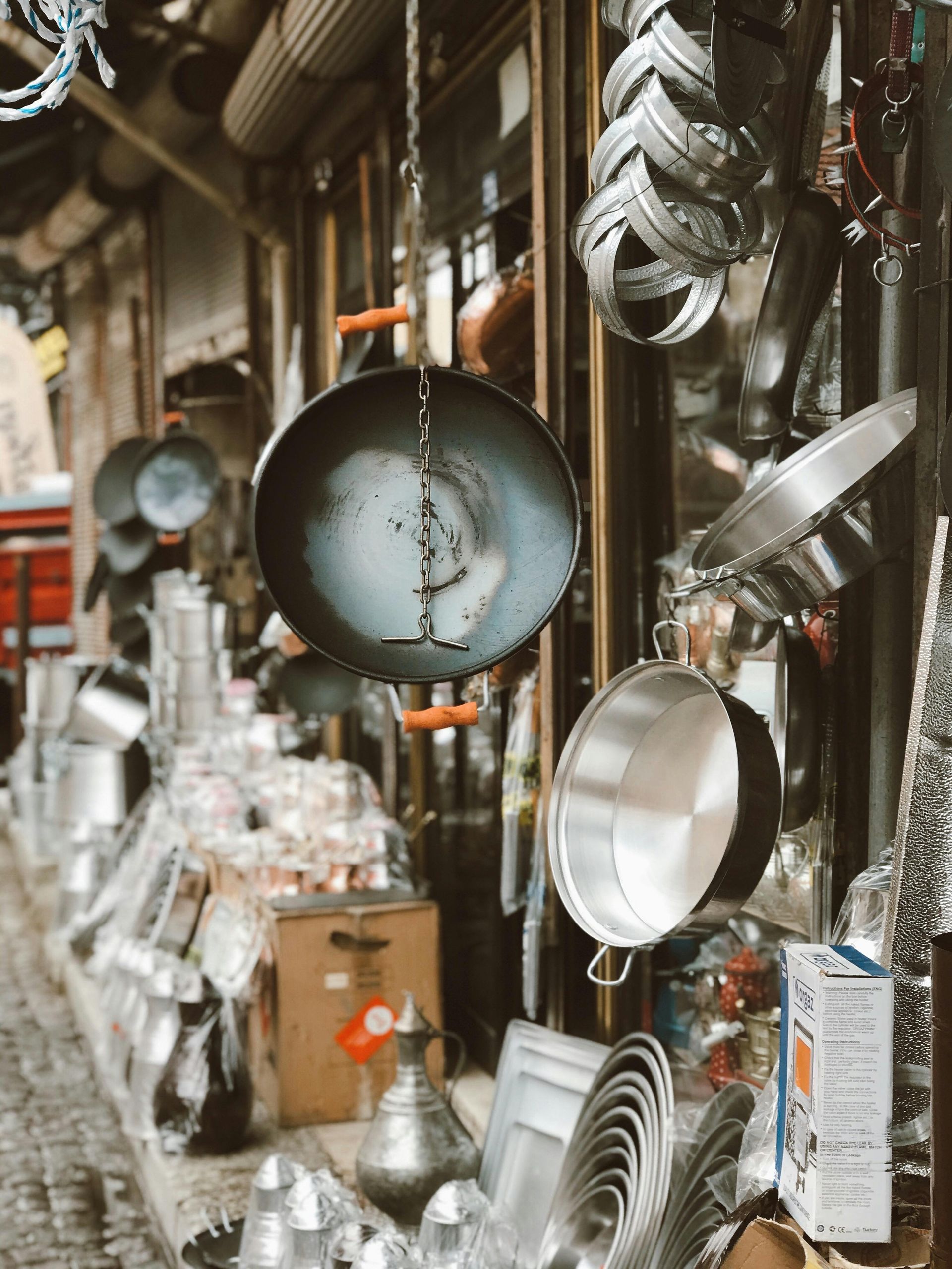 A store filled with lots of pots and pans hanging from the ceiling.