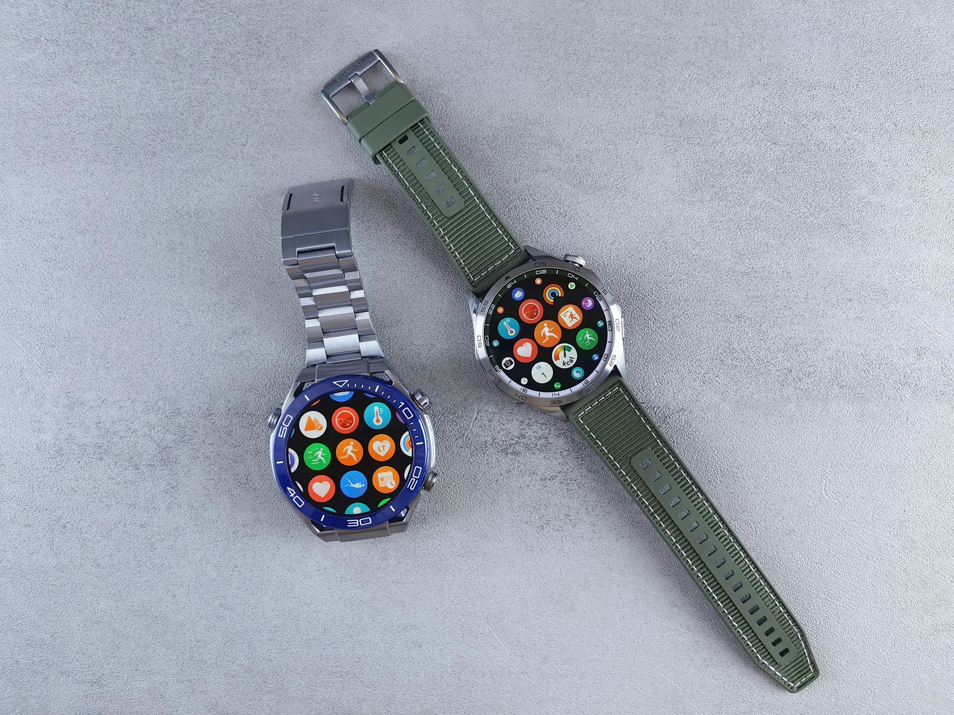 Two watches are sitting next to each other on a table.