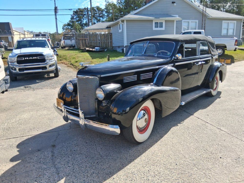 Person changing a car tire with a jack; wheel is being removed with a wrench.