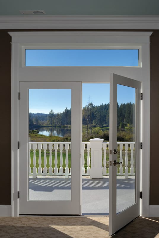An open door with a view of a lake and trees