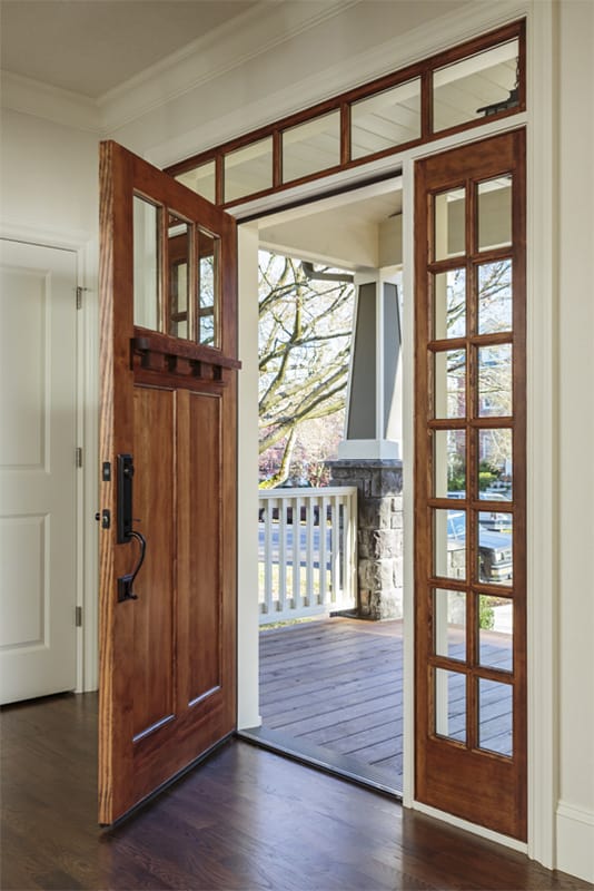 A wooden door is open to a porch in a house.