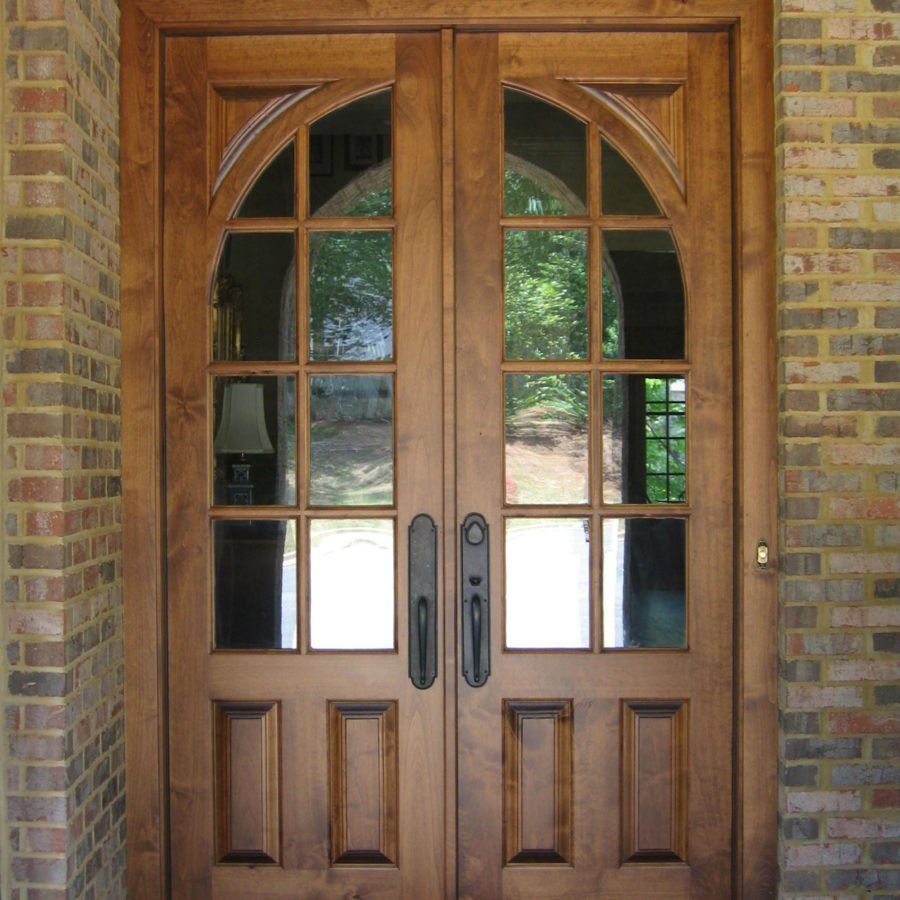A wooden door with a brick wall behind it