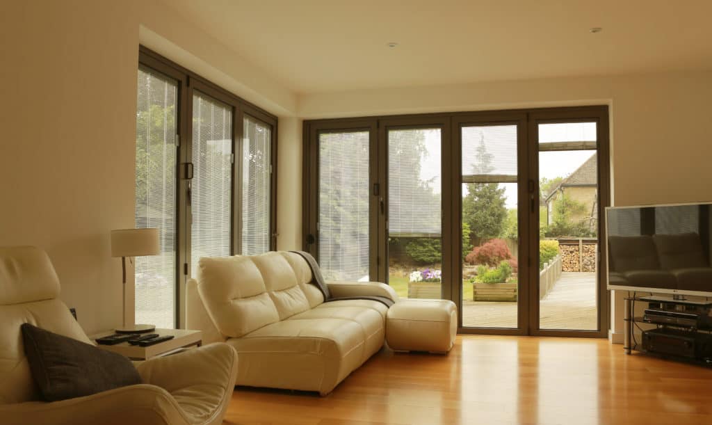 A living room with a couch , chairs , and a flat screen tv.